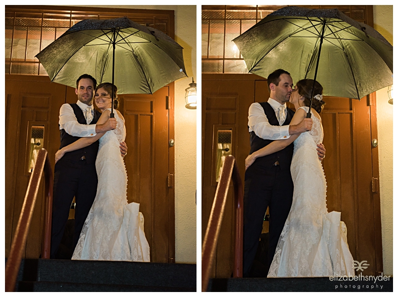 Bride and groom share a moment in the rain at the end of the night